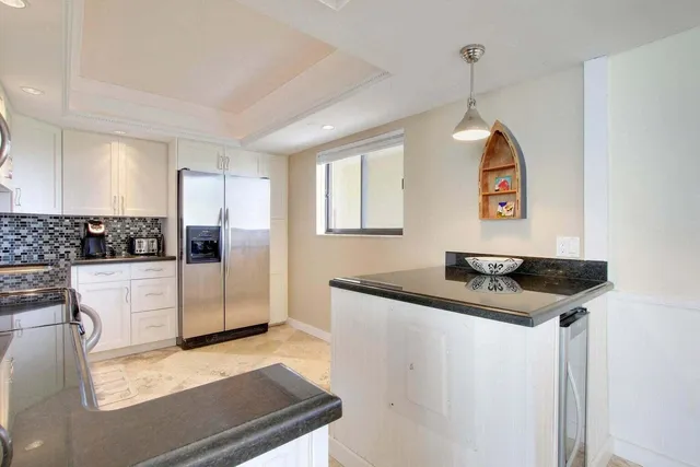 a kitchen with stainless steel appliances granite countertop a sink refrigerator and microwave