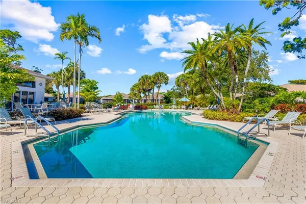 a view of a swimming pool with an outdoor seating and a yard