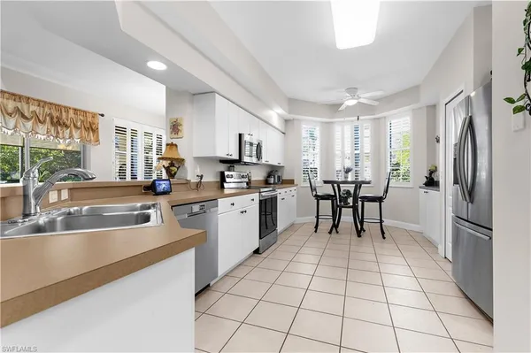 a kitchen with stainless steel appliances granite countertop a refrigerator and a stove top oven