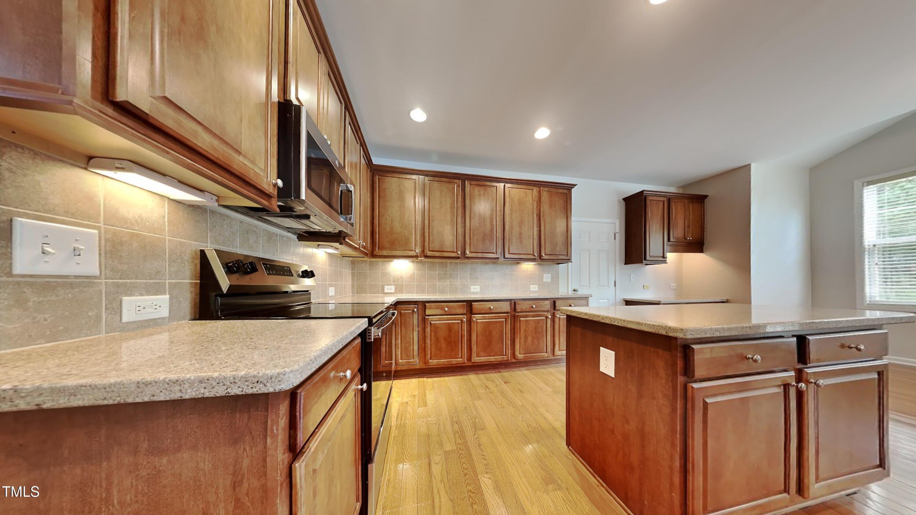 9037 Linslade Way Wake Forest, NC 27587 - Photo 5 of 16 a kitchen with stainless steel appliances granite countertop a sink stove and cabinets