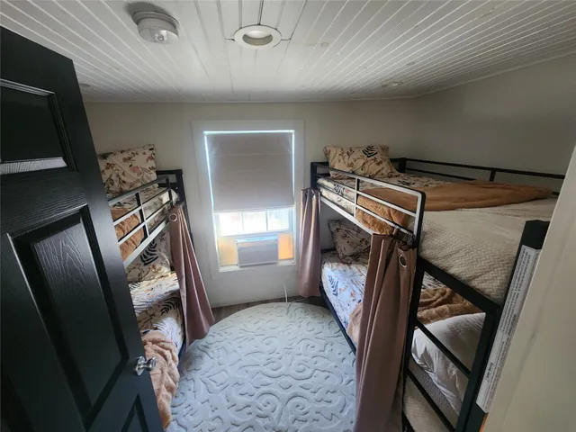 a view of a hallway with furniture and a ceiling fan