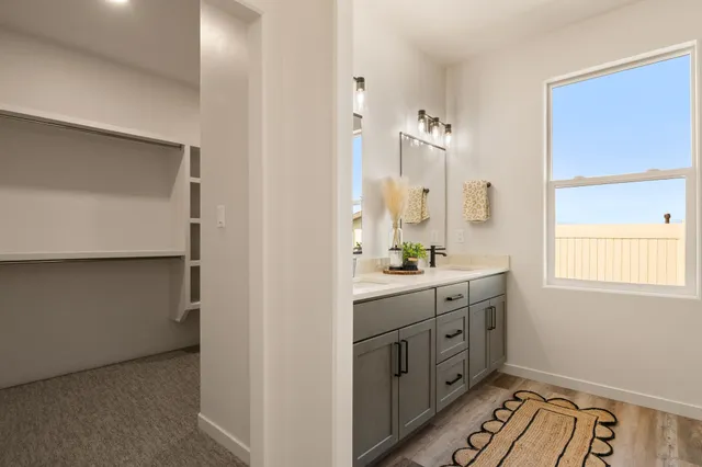 a bathroom with a double vanity sink a mirror and a bathtub