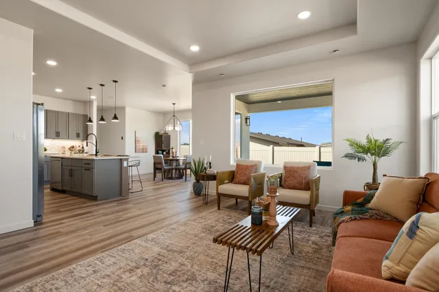 a living room with furniture kitchen view and a large window