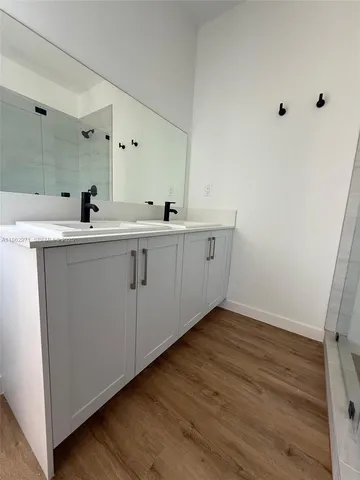 a bathroom with a granite countertop sink toilet a mirror and bathtub