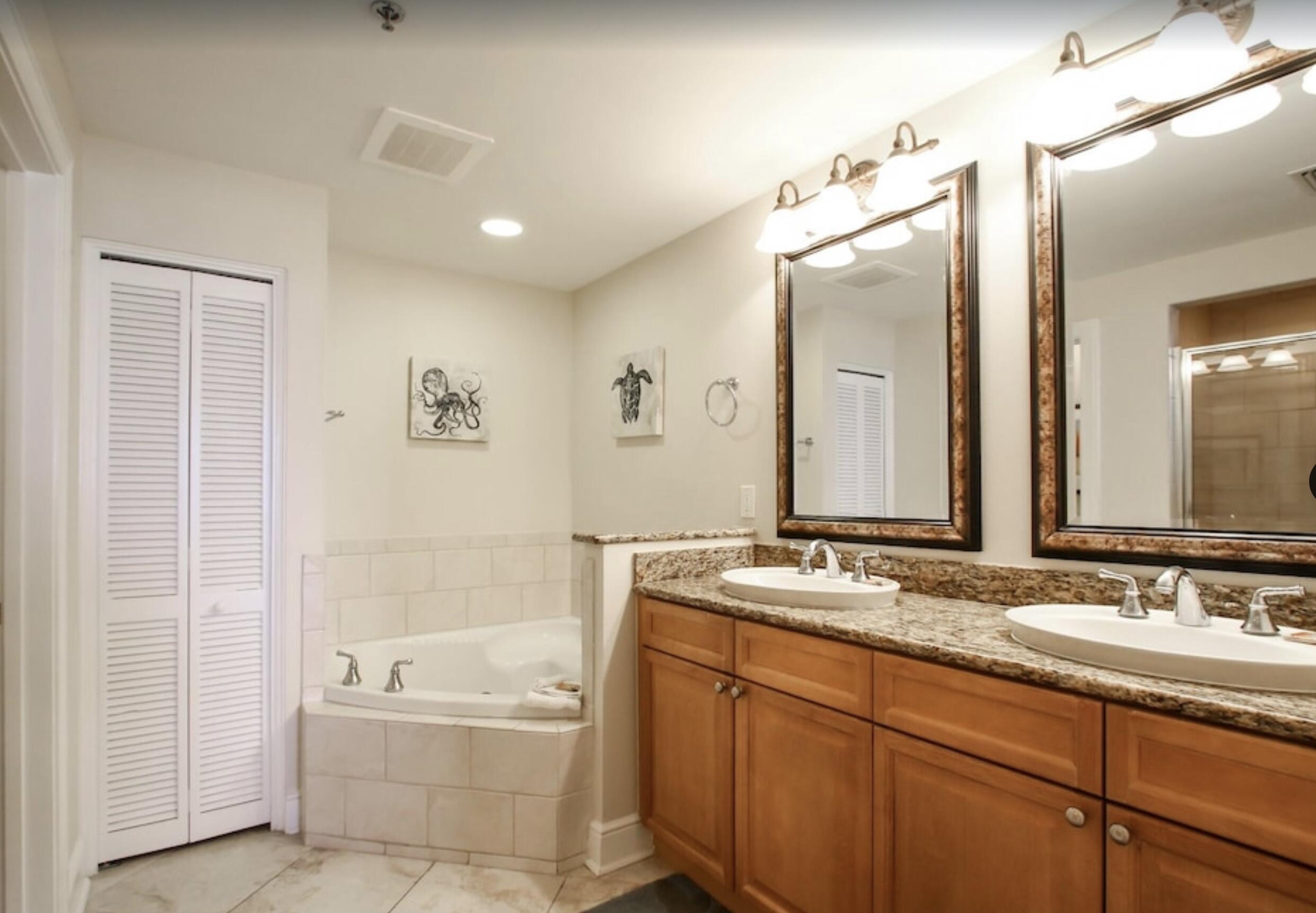 1150 Santa Rosa Boulevard, Unit 211 Fort Walton Beach, FL 32548 - Photo 5 of 7 a bathroom with a granite countertop sink a mirror a bathtub and shower