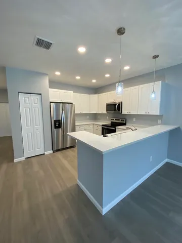 a kitchen with stainless steel appliances granite countertop a stove top oven a refrigerator a sink and a oven