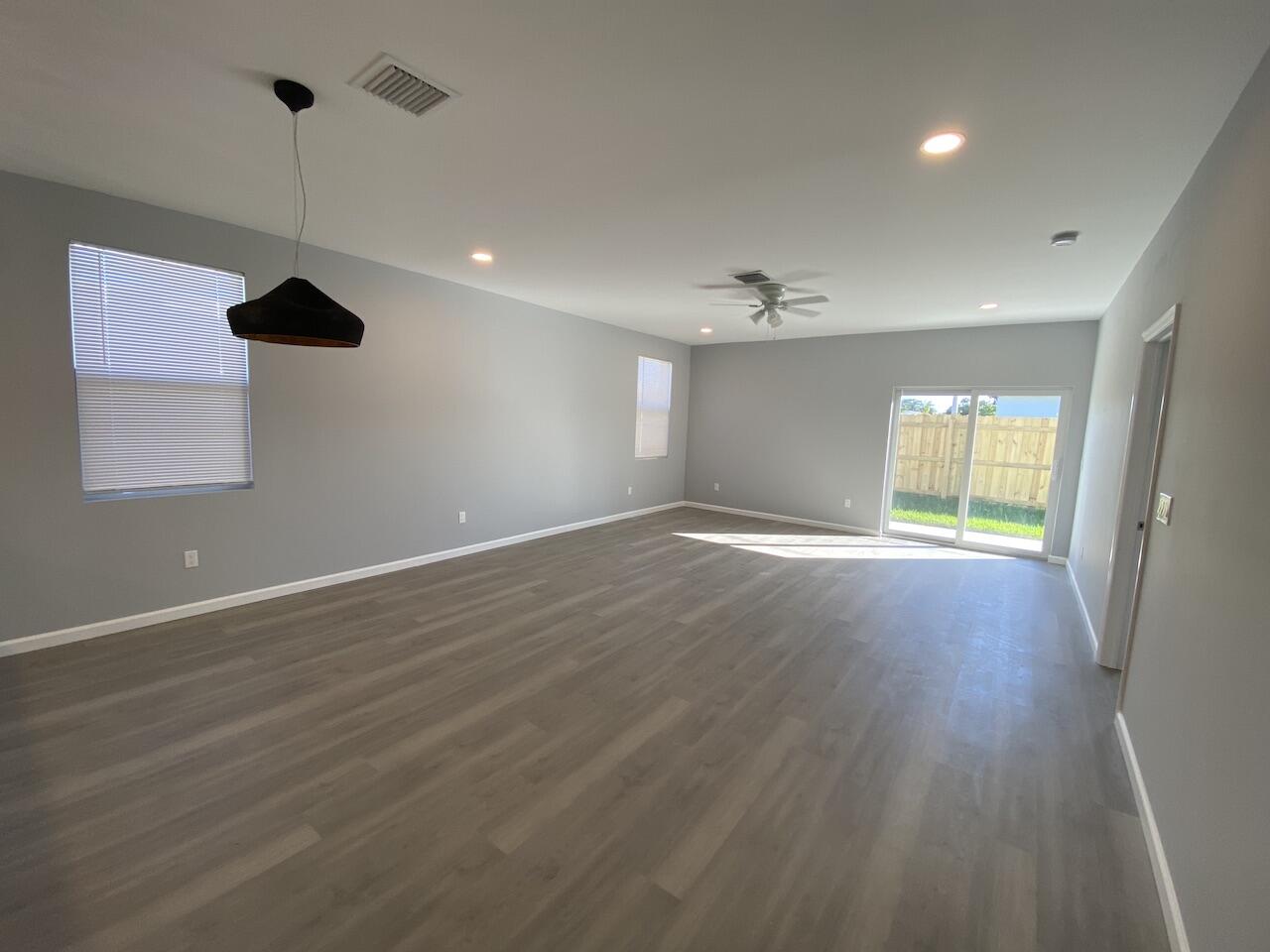 514 Northwest 11th Avenue Boynton Beach, FL 33435 - Photo 6 of 18 an empty room with wooden floor and windows