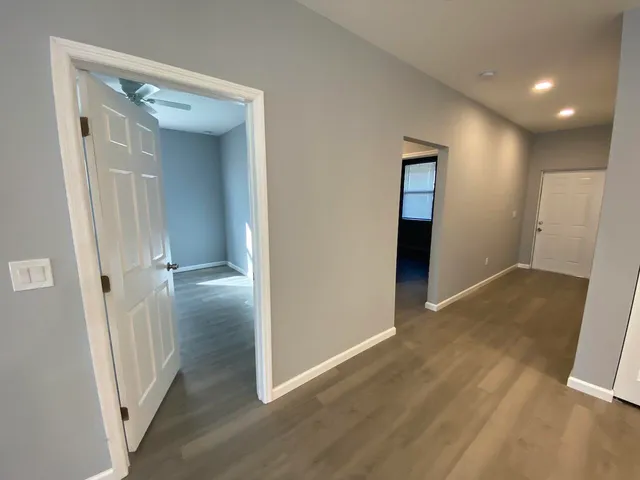 a view of a hallway with wooden floor