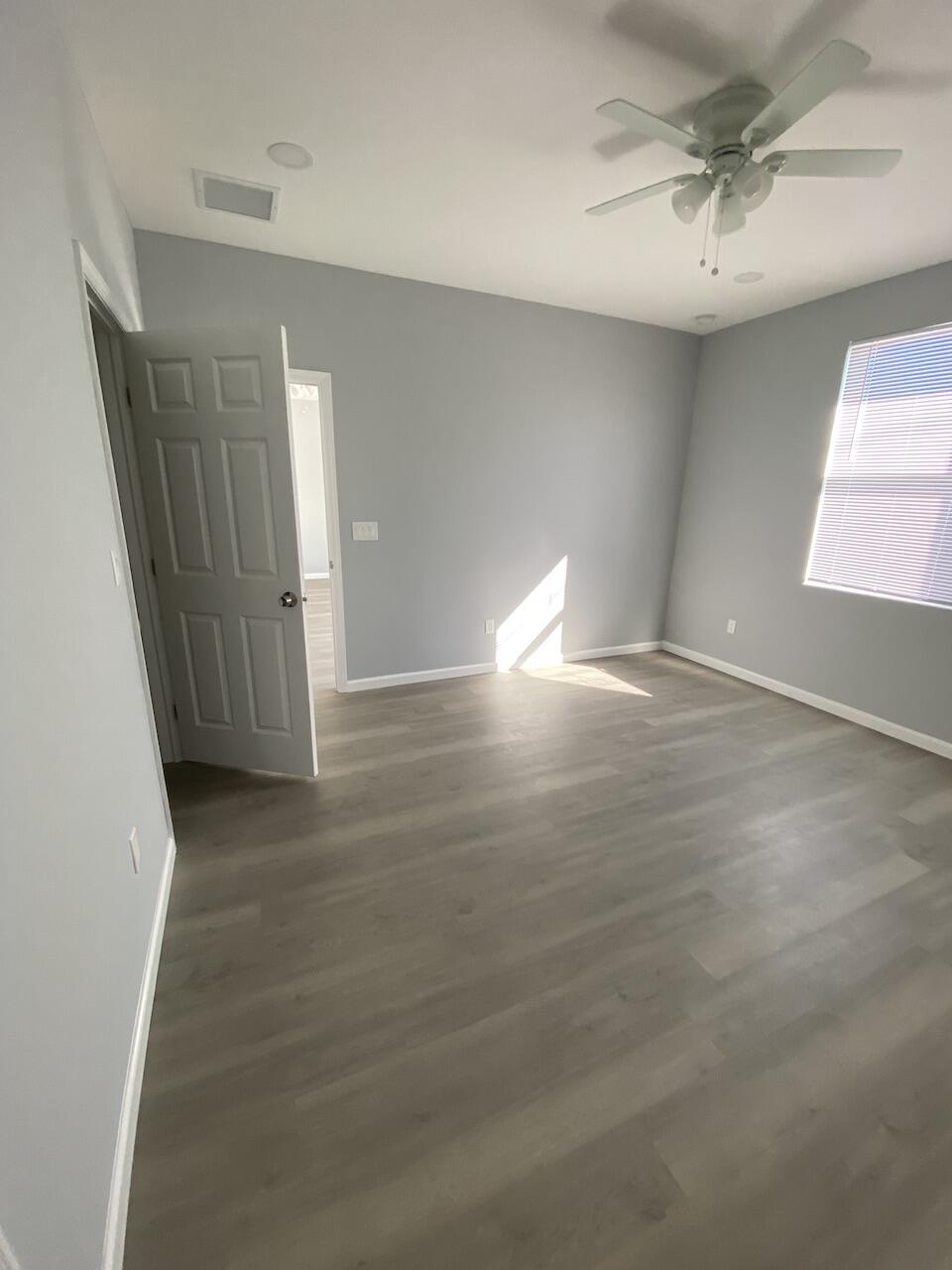 514 Northwest 11th Avenue Boynton Beach, FL 33435 - Photo 8 of 18 an empty room with wooden floor and fan
