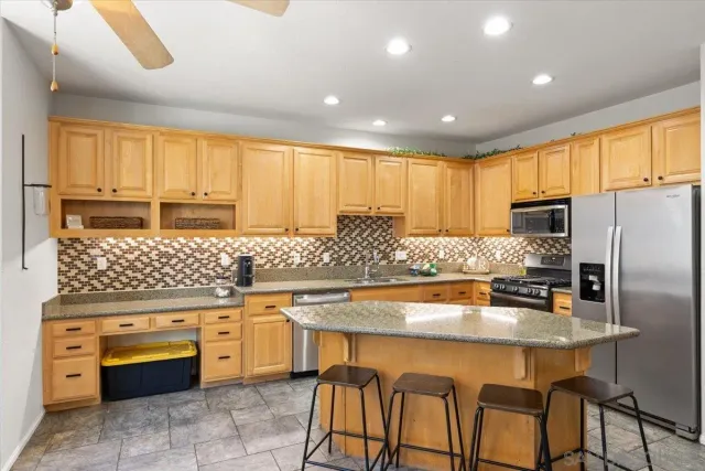 a kitchen with stainless steel appliances granite countertop a stove top oven a refrigerator a sink and dishwasher
