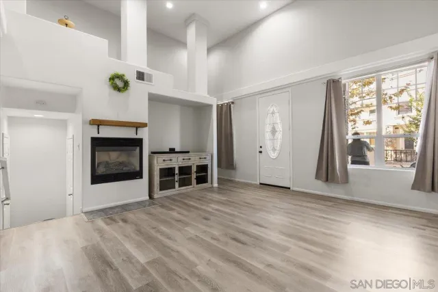 wooden floor fireplace and windows in an empty room