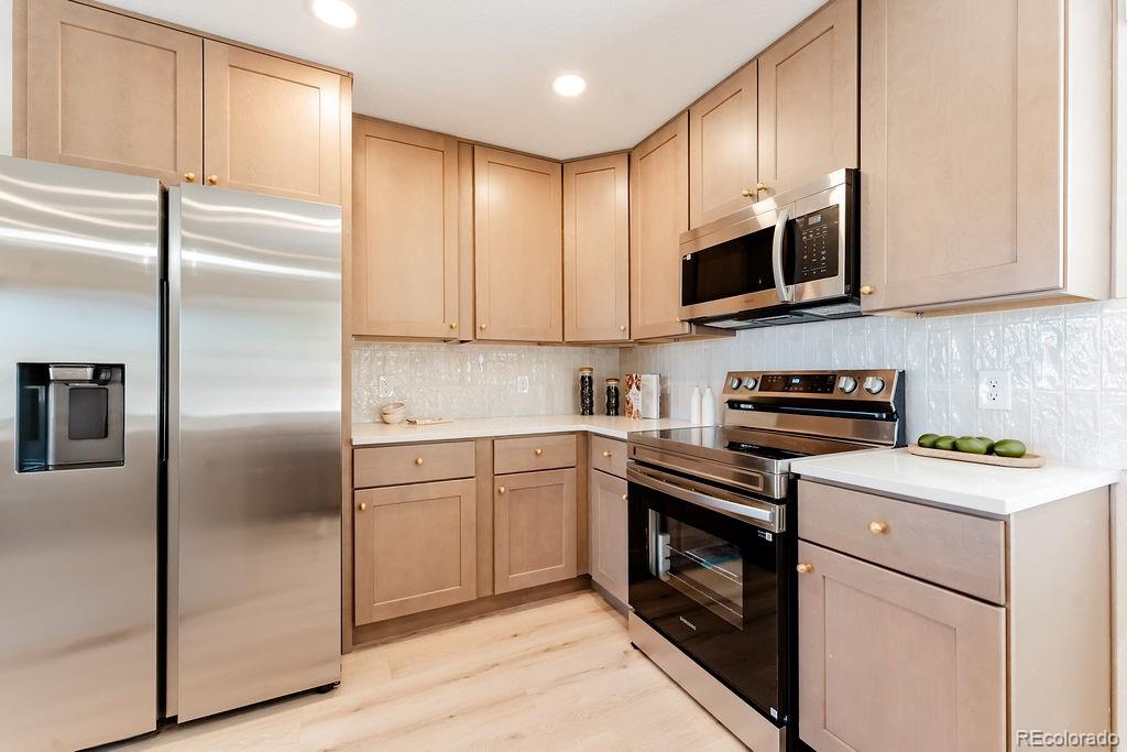 1105 South Raleigh Street Denver, CO 80219 - Photo 8 of 23 a kitchen with stainless steel appliances granite countertop a refrigerator a stove a sink and a microwave