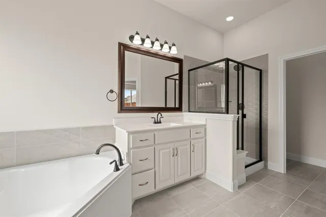 a bathroom with a double vanity sink mirror and bathtub