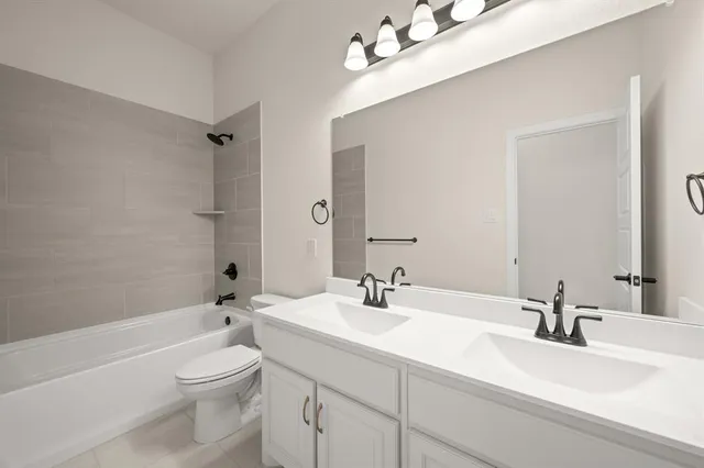 a bathroom with a sink a toilet and a large mirror