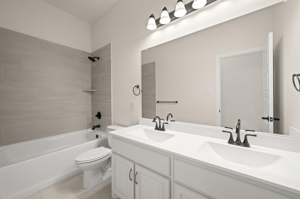 104 Calf Lane Midlothian, TX 76065 - Photo 19 of 29 a bathroom with a sink a toilet and a large mirror