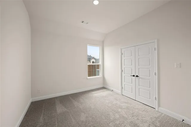 an empty room with windows and closet