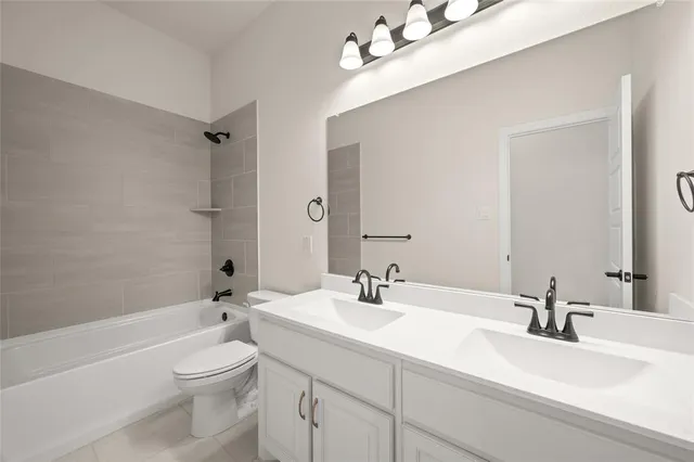 a bathroom with a sink a toilet and a large mirror