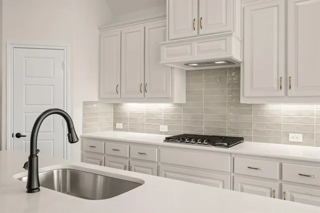 a kitchen with stainless steel appliances kitchen island a sink a stove and cabinets