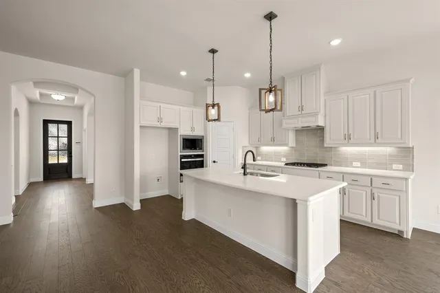a kitchen with stainless steel appliances kitchen island a sink stove and cabinets