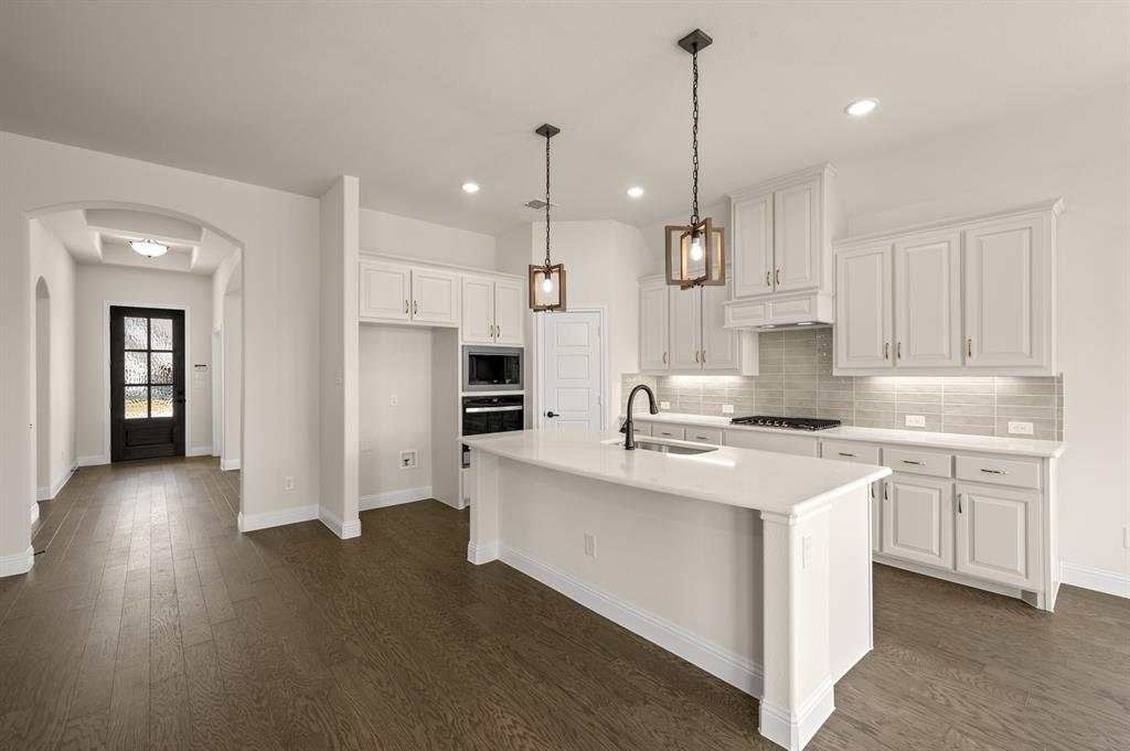 104 Calf Lane Midlothian, TX 76065 - Photo 5 of 29 a kitchen with stainless steel appliances kitchen island a sink stove and cabinets