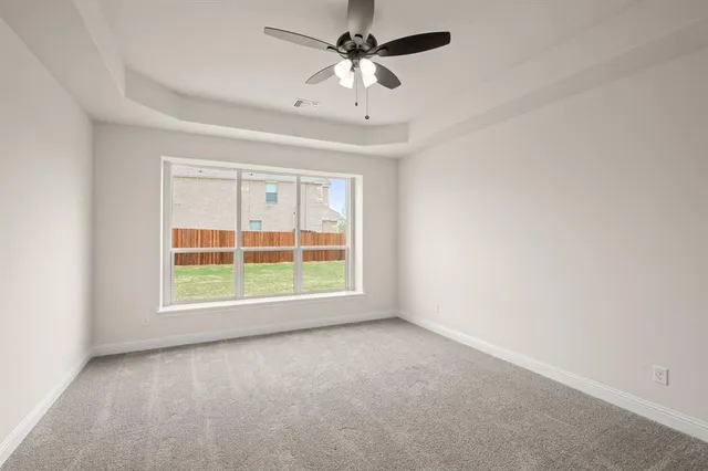 an empty room with a window and a fan