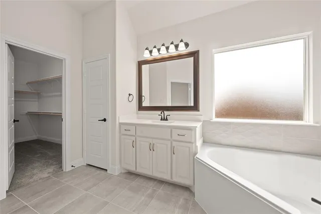 a bathroom with a tub sink and mirror
