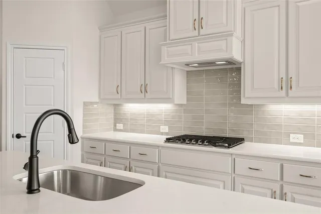 a kitchen with sink a stove and cabinets