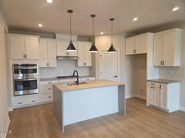 a kitchen with kitchen island a sink stove and refrigerator