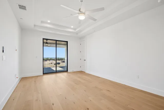 wooden floor in an empty room with a ceiling fan