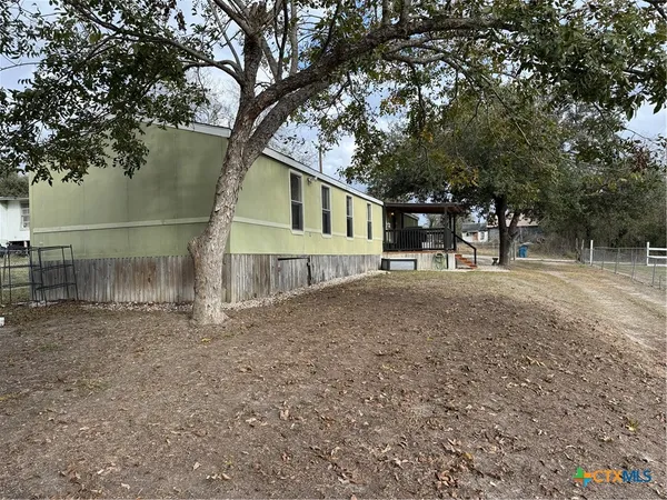 a front view of a house with a tree