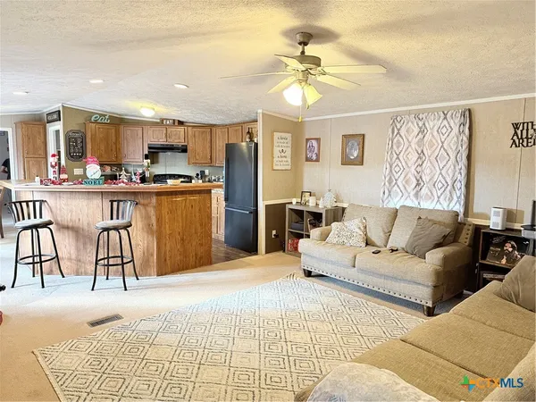 a living room with furniture and a dining table with kitchen view