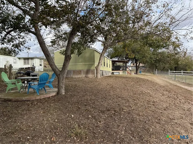 a backyard of a house with table and chairs