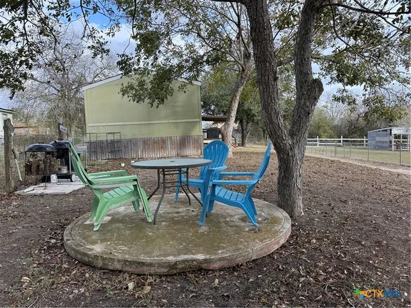 a backyard of a house with table and chairs