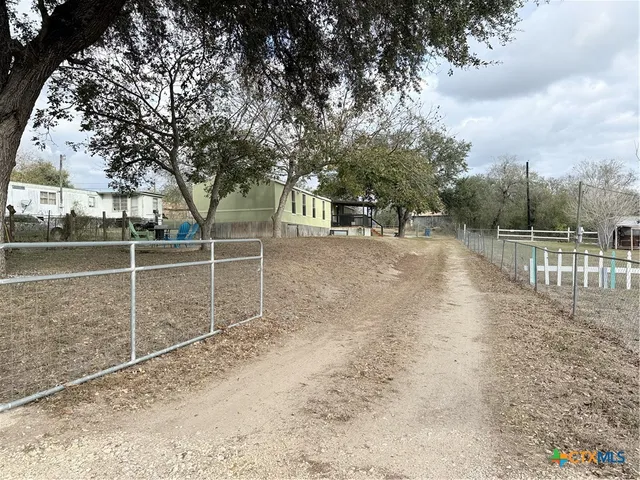 a view of a yard with wooden fence