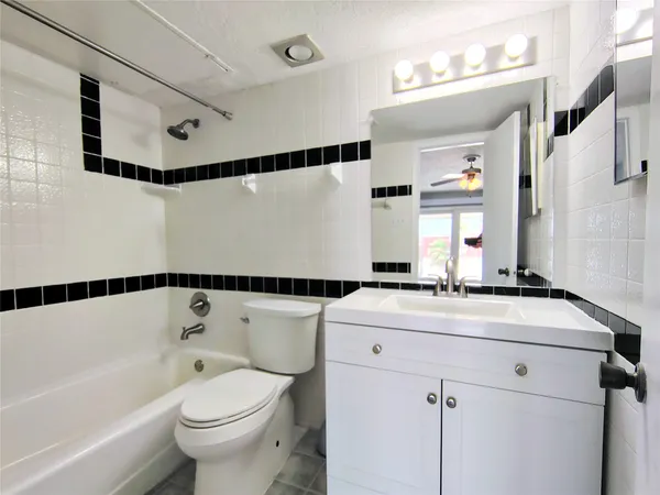 a bathroom with a sink a toilet a mirror and shower