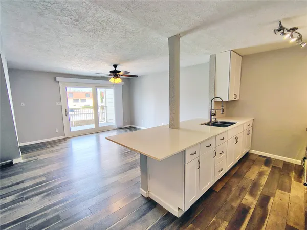 a kitchen with wooden floors and windows