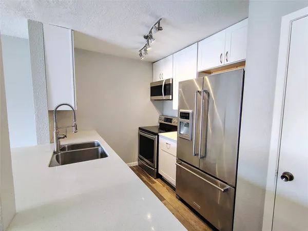 a kitchen with a refrigerator and a sink