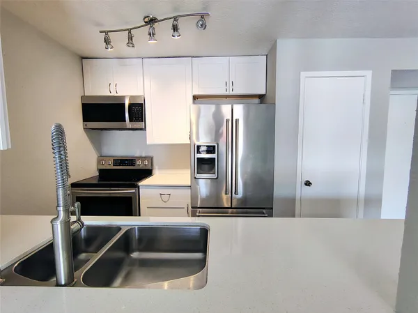 a kitchen with a refrigerator and a sink