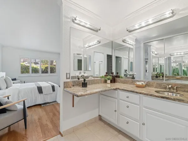 a spacious bathroom with a granite countertop sink mirror and