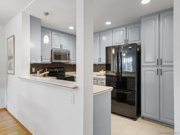 a kitchen with stainless steel appliances a refrigerator a stove top oven and cabinets