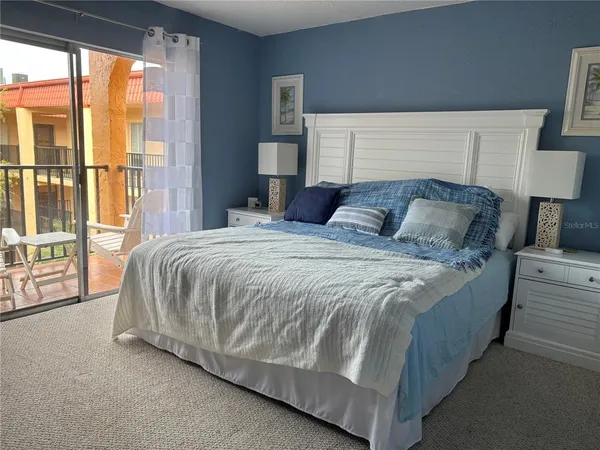 a large bed sitting in a bedroom next to a large window
