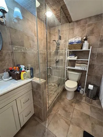 a bathroom with a granite countertop sink a toilet and shower
