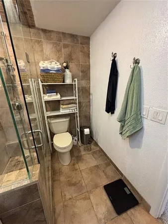 a bathroom with a toilet and a shower