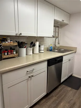 a kitchen with stainless steel appliances granite countertop a sink and a white cabinets