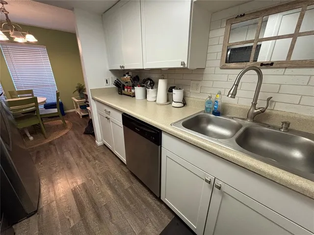 a kitchen with stainless steel appliances a sink dishwasher stove refrigerator and cabinets