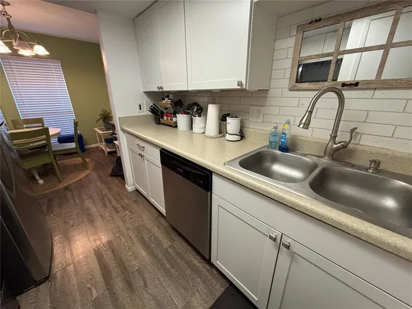 a kitchen with stainless steel appliances a sink dishwasher stove refrigerator and cabinets