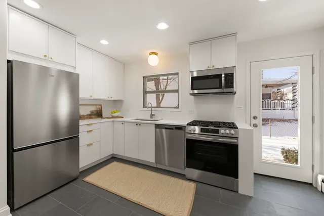 a kitchen with cabinets stainless steel appliances and wooden floor