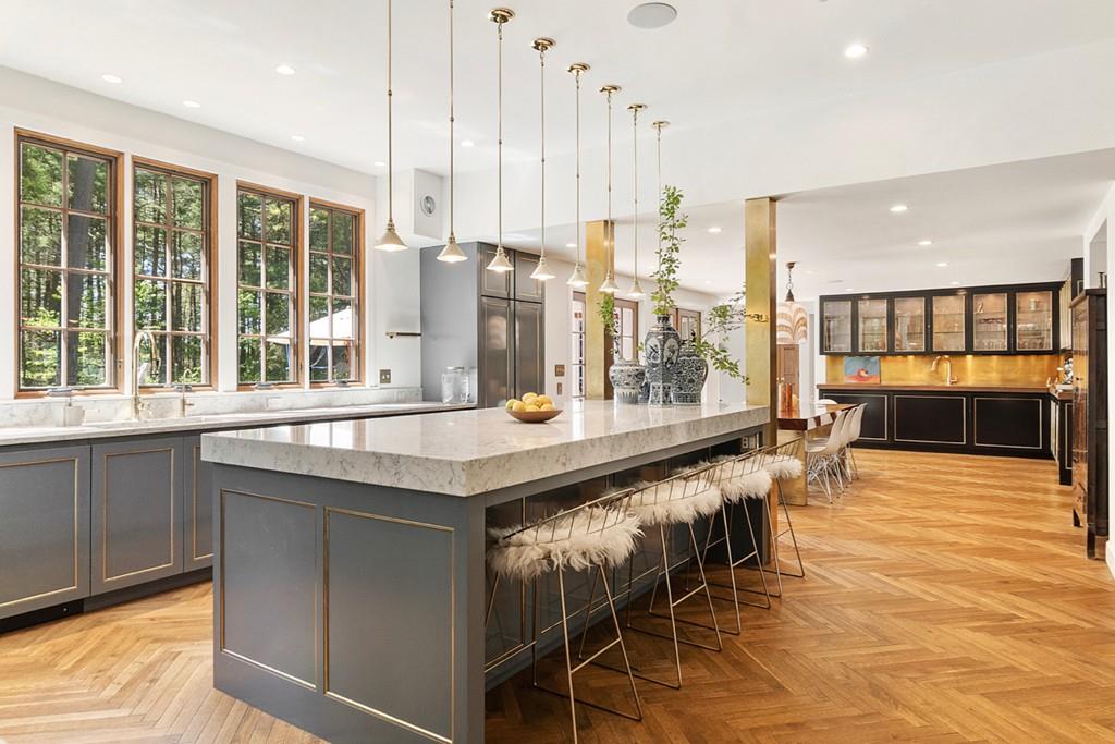 a large kitchen with kitchen island granite countertop a table and chairs in it