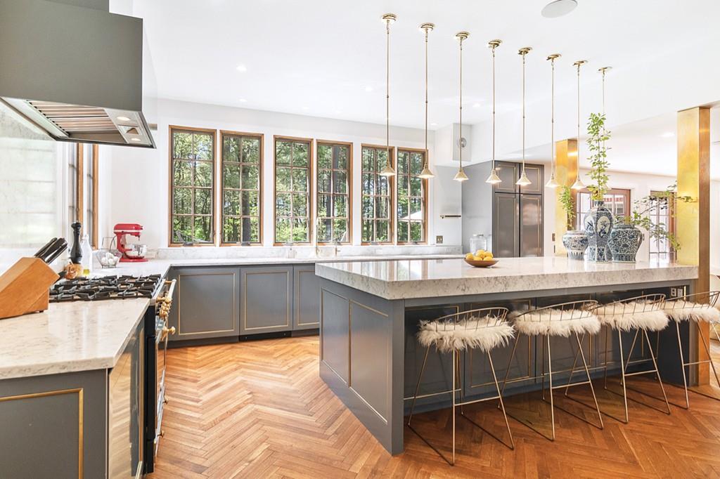 107 Independence Road Concord, MA 01742 - Photo 4 of 25 a kitchen with kitchen island granite countertop a stove a sink and white cabinets with wooden floors
