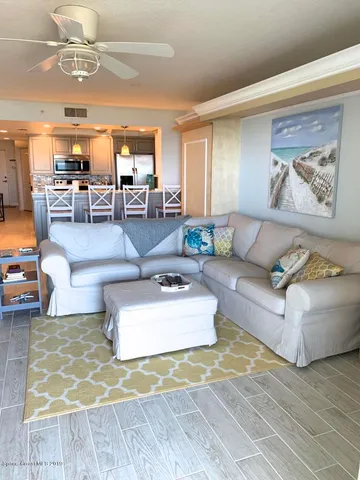 a living room with furniture and view of kitchen